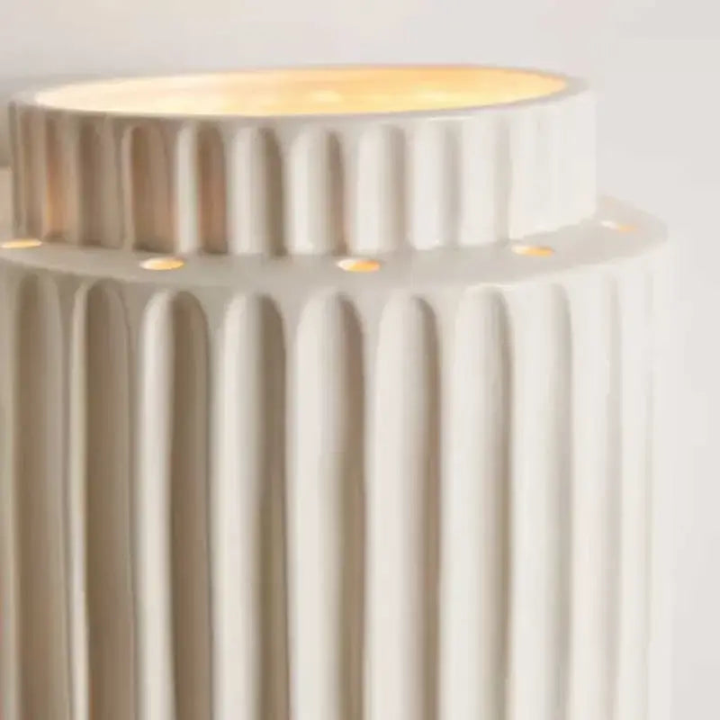 Cream white resin wall sconce with vertical ridges and a glowing top by decorbites cream white for bedroom decor