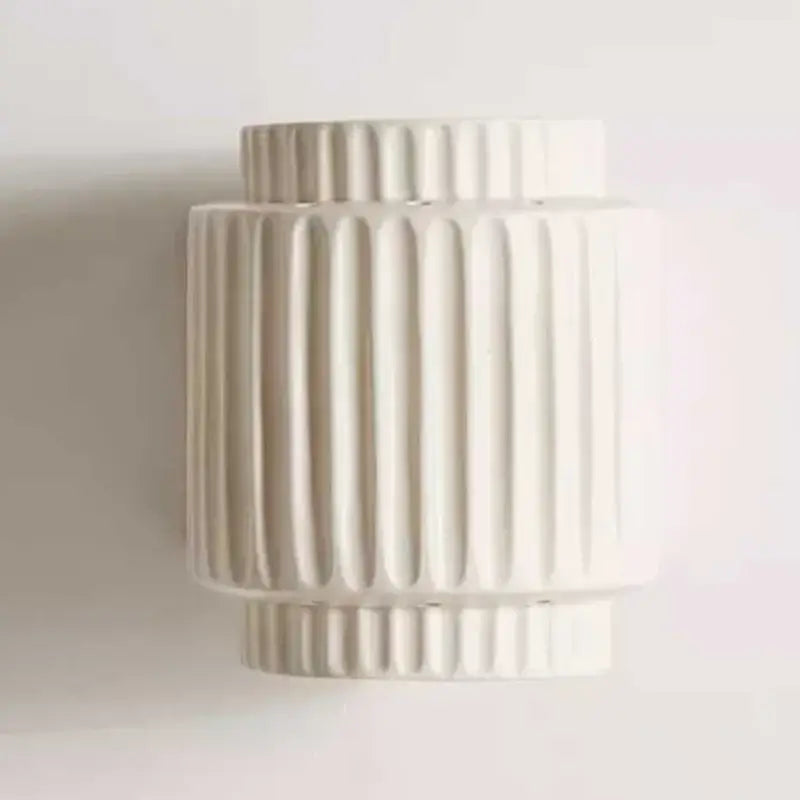 Off-white ceramic vase with vertical ribbed texture and tiered cylindrical shape for decorbites cream white wall sconce
