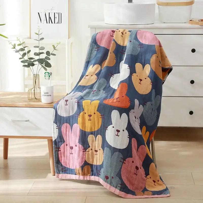 A cozy navy blue cotton bath towel with colorful cartoon bunnies complements romantic beige and black floral decor