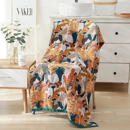 A cozy cotton bath towel with a quilted tropical leaf and floral pattern in orange teal and cream for bathroom decor