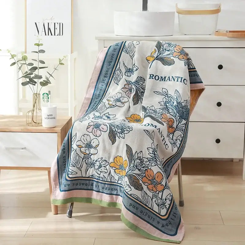 Romantic beige and black floral cotton bath towel with delicate colored pattern and the word romantic on the border