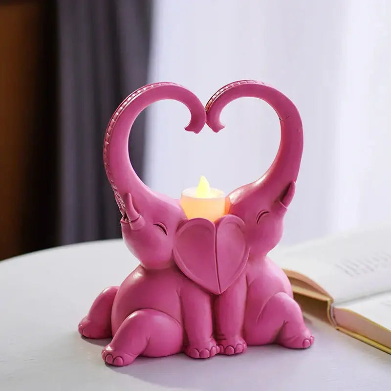 Pink resin elephant couple candlestick with heart-shaped trunks framing lit flame for romantic decorbites decorbites elephant couple