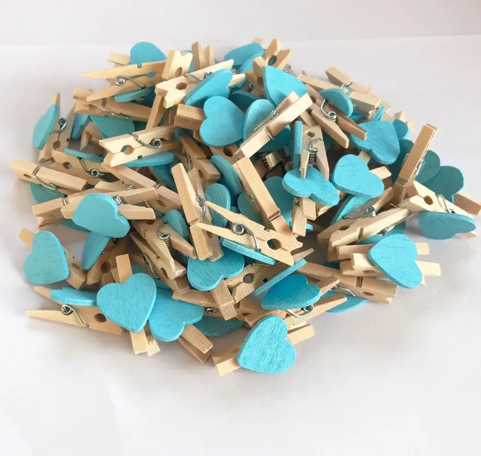 A pile of turquoise romantic heart shape wood clips with natural wood accents and metal springs for bedroom decor