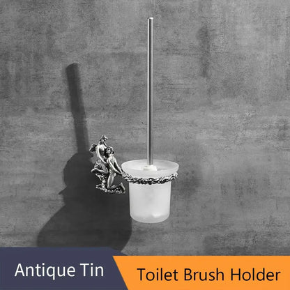 Antique tin toilet brush holder with frosted glass base and silver angel accent in a romantic bathroom hardware set