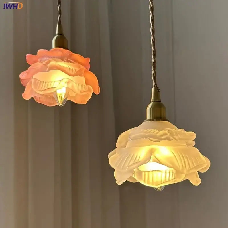 Two pendant lights with rose and white glass knob switch shades in warm tones and brass fixtures for bedroom lighting