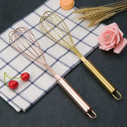 Two elegant rose gold and brass steel egg beaters with sleek handles and fine wire loops from decorbites gold steel set