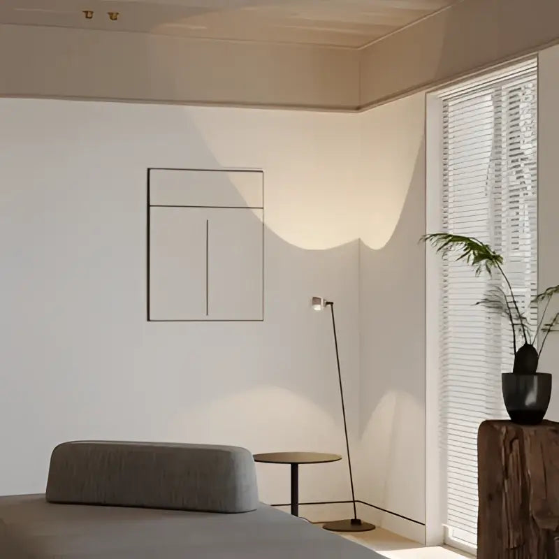 Gray textured cushion on a modern sofa next to a rose gold decorbites designer fishing floor lamp for living room decor