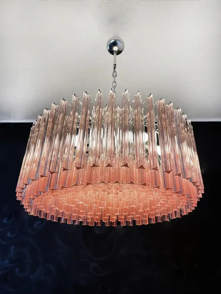 Rose gold pink glass chandelier with cascading translucent pink glass rods suspended from a polished silver fixture