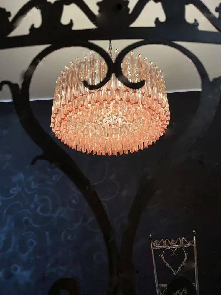 Rose gold pink glass chandelier with tiered cylindrical design featuring slender faceted rods for living room use