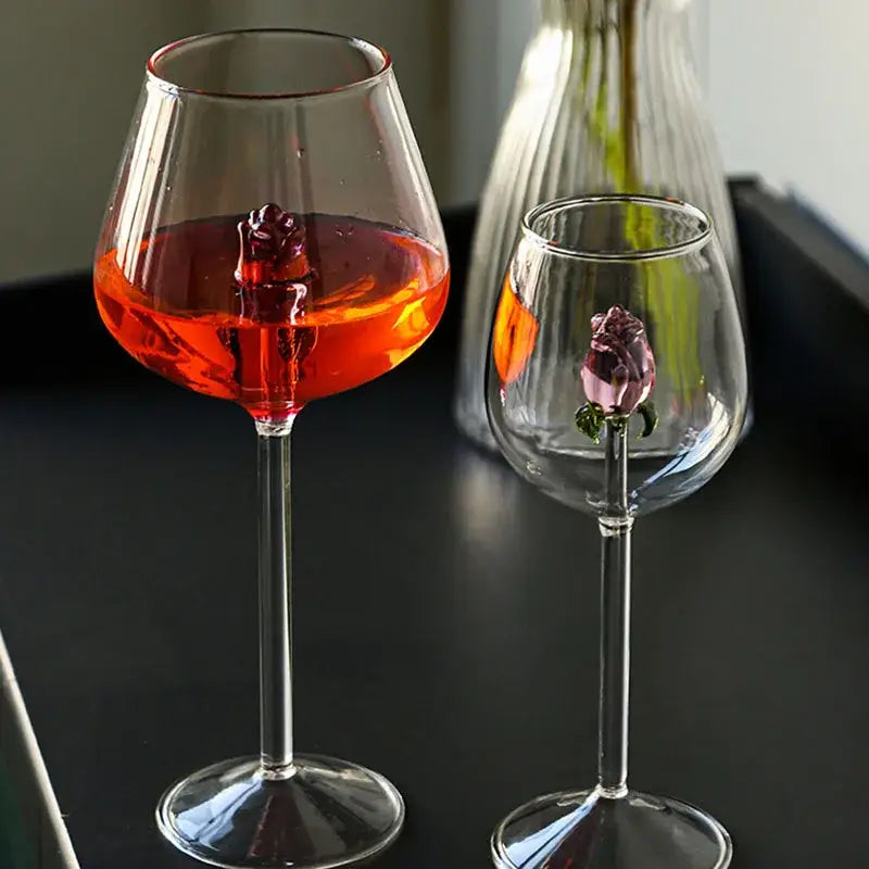 Clear glass rose stemware wine glass with pink decorbites 3d rose embellishments and one filled with red wine