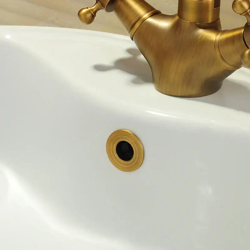 Brass-colored circular sink drain overflow cover with concentric ring design for kitchen and bathroom decorbites brass sink