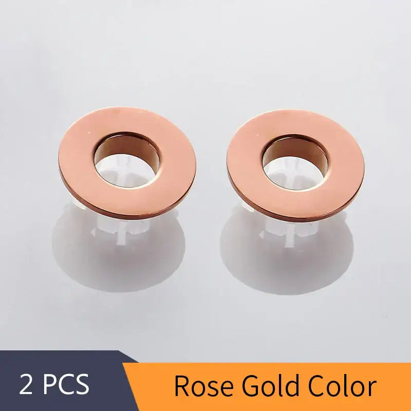 Rose gold brass sink overflow cover set featuring round metal grommets with smooth circular design inserts