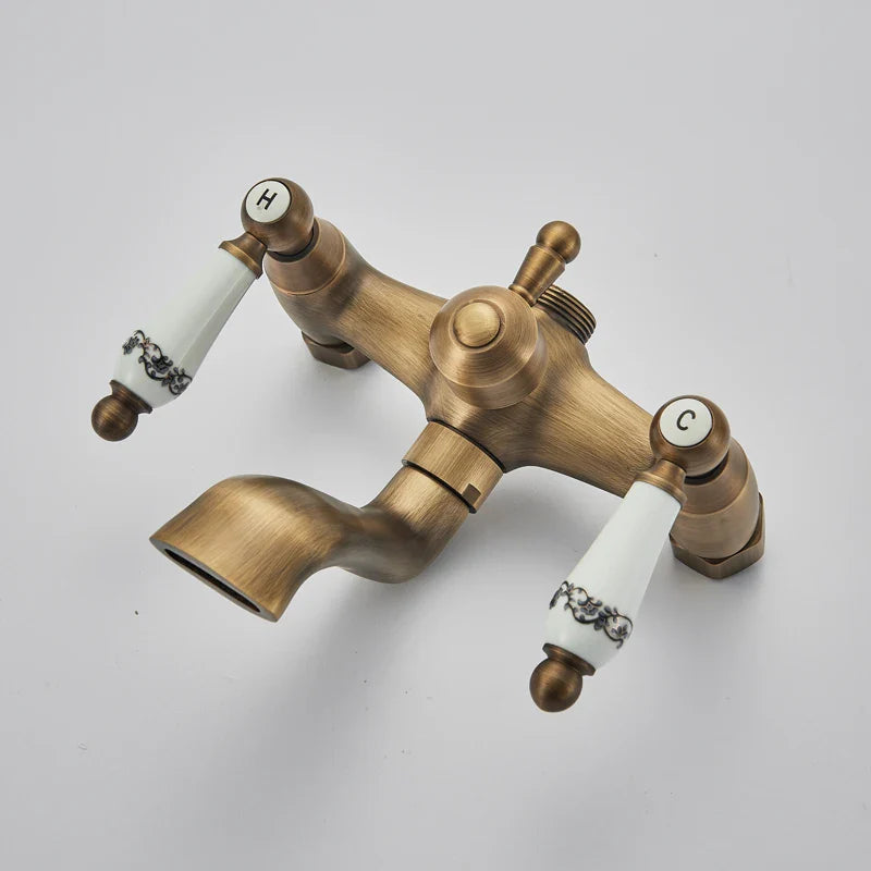 Antique brass shower faucet with white ceramic handles featuring black floral patterns labeled h for hot and c for cold