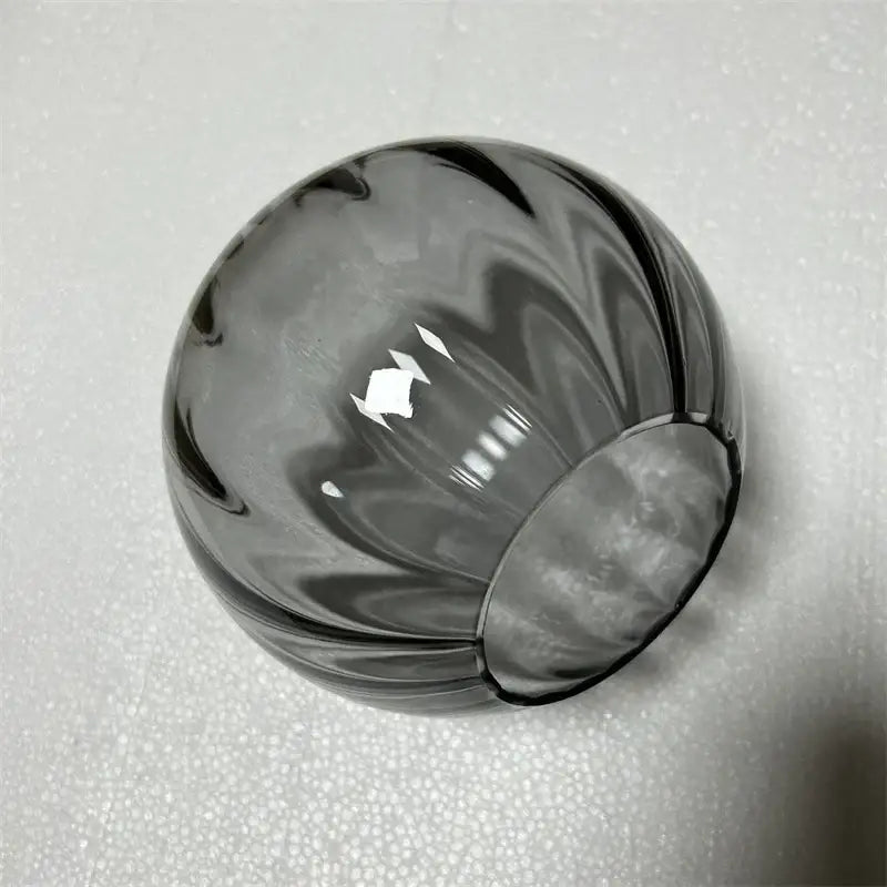 A translucent gray glass ball pendant lamp with swirling ribbed design for living room decorbites glass ball decor