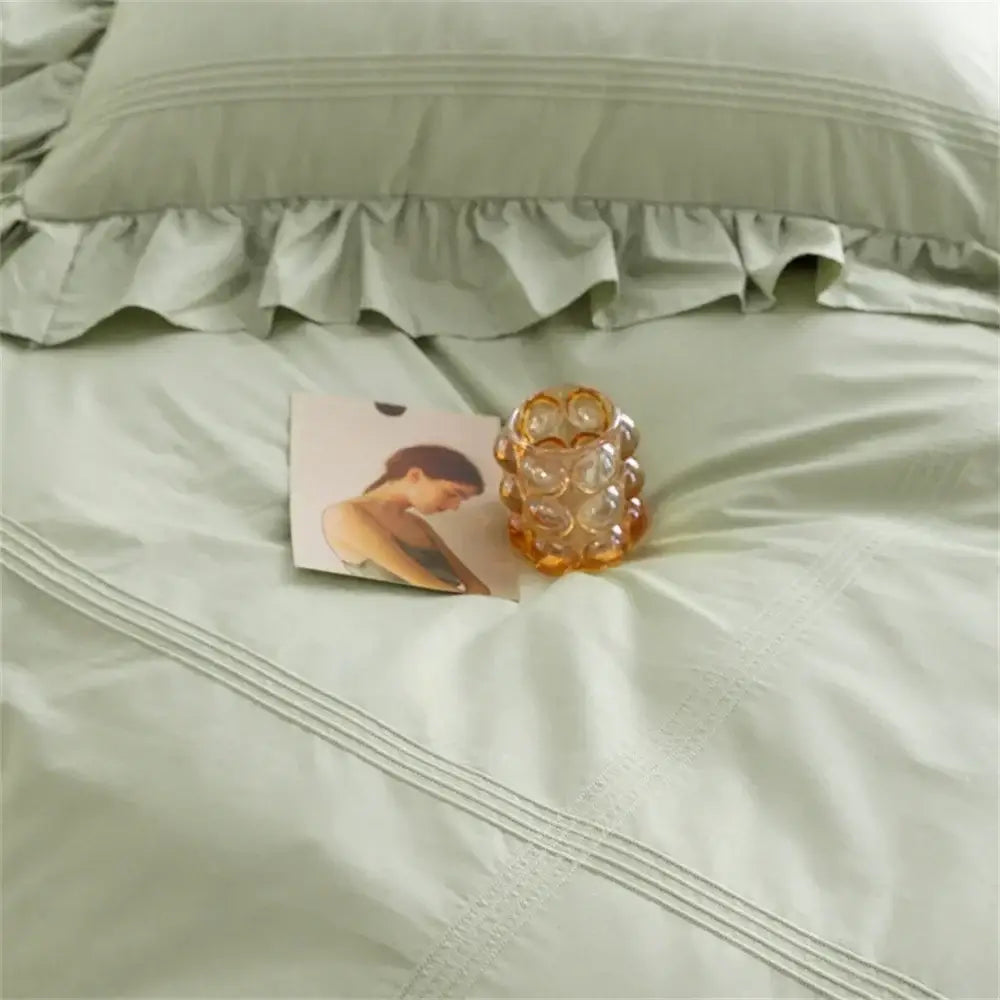 A translucent amber glass candle holder with textured bubble design complements decorbites light green bedding set