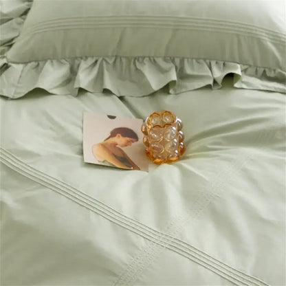 A translucent amber glass candle holder with textured bubble design complements decorbites light green bedding set