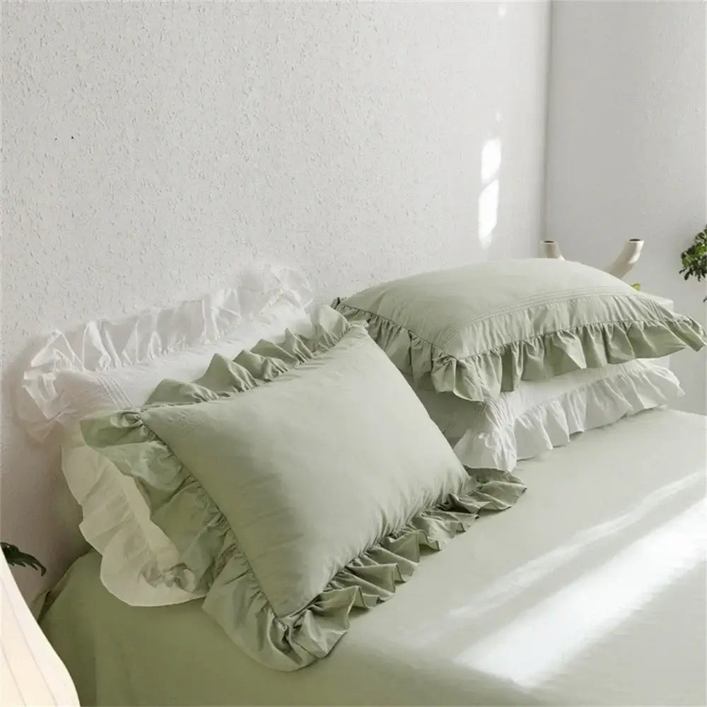 Soft sage green pillowcases with white ruffled edges in a light green egyptian cotton bedding set by decorbites