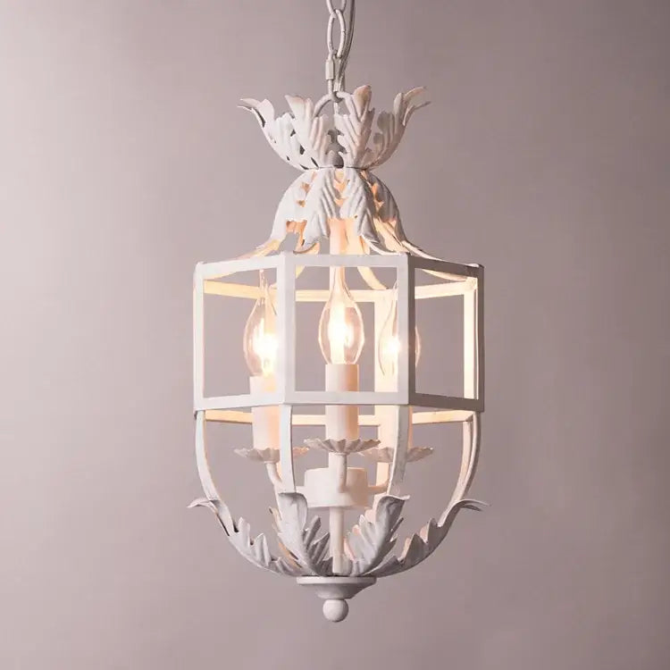 White wrought iron lantern with leafy accents and three exposed bulbs in decorbites grey gold metal cage chandelier design