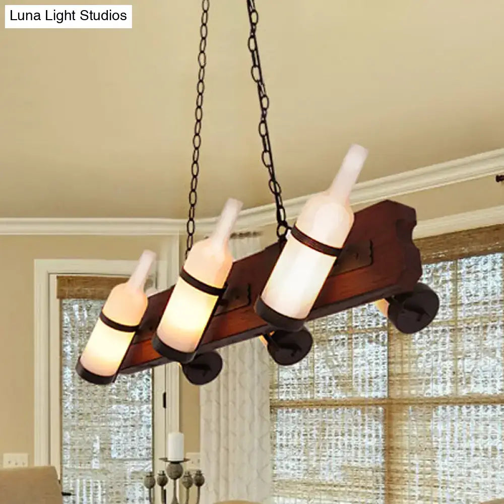 Rustic island lamp with brown wood arm and frosted white glass wine bottle shades suspended by black chains
