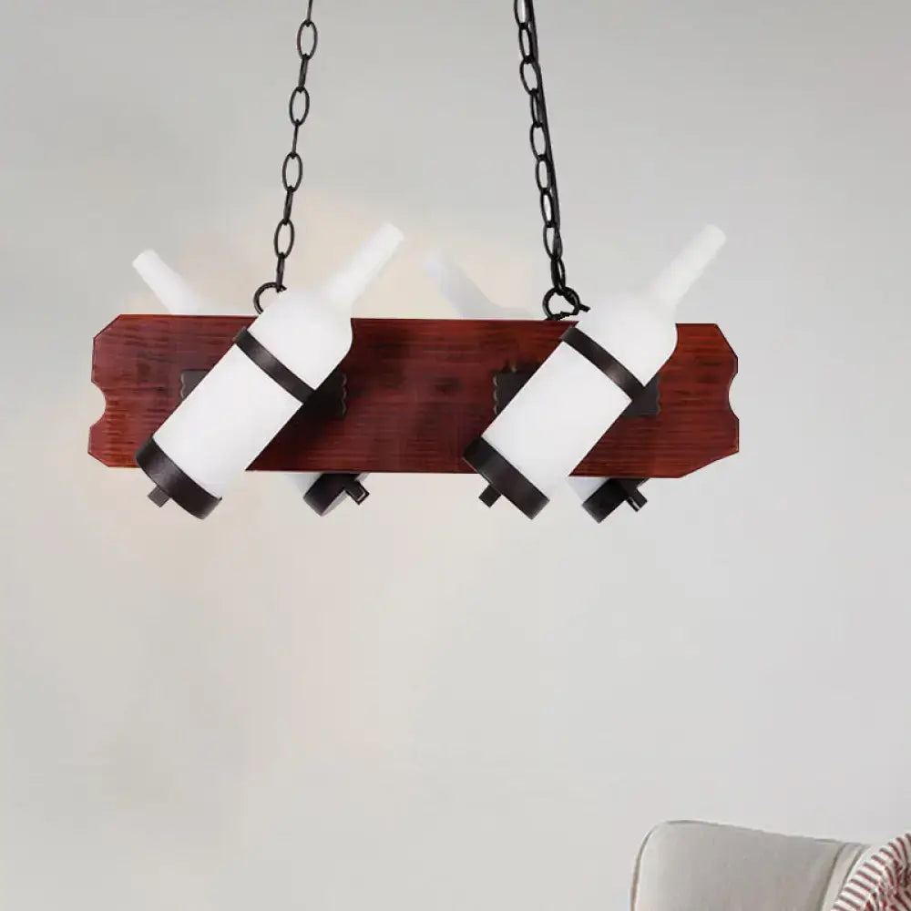 Rustic island lamp with brown wood arm and frosted white glass wine bottle shades suspended by black metal chains