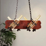 Rustic island lamp with brown wood arm featuring frosted white and amber glass wine bottles on dark chains