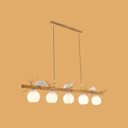 DecorBites modern cream glass wood light fixture with white bird deco and frosted globes for dome island spaces
