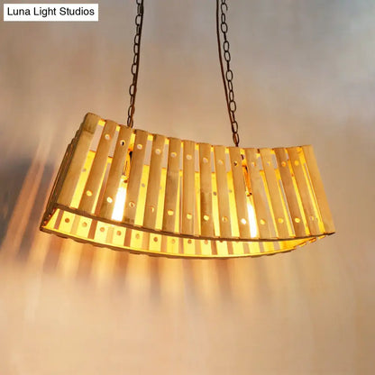 Golden curved bamboo linear island pendant light with vertical slats and circular cutouts for dining table lighting