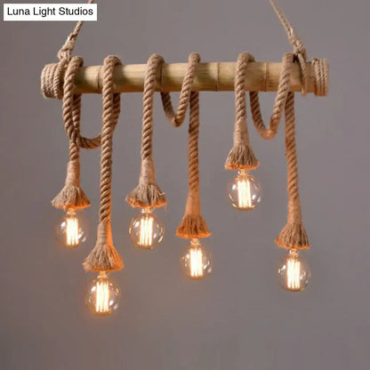 Rustic bamboo pendant with thick beige adjustable rope and frayed tassels holding clear bulbs in rope island light design