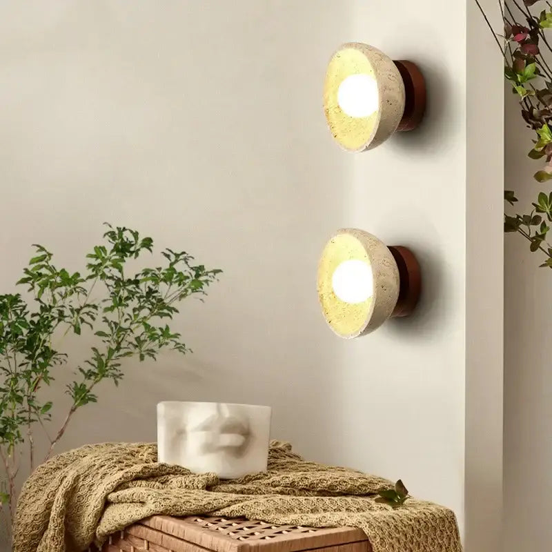 Two beige travertine base wall lights with warm wooden decorbites led wall sconces emitting soft bedroom glow