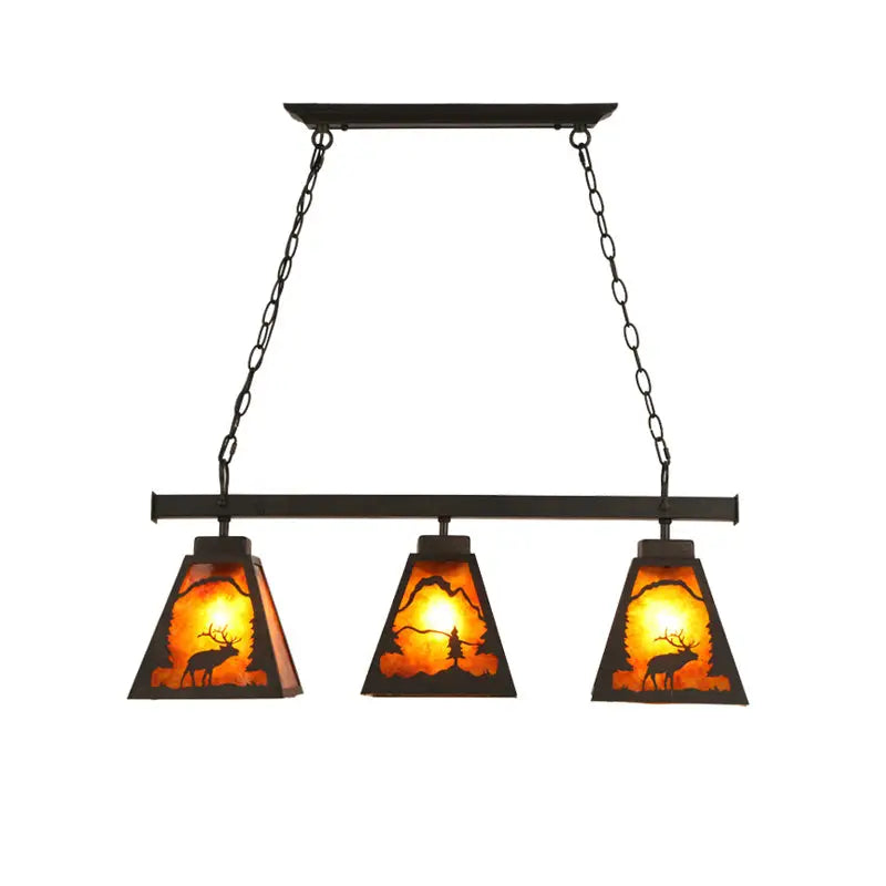 Rustic black metal pendant light with three amber glass shades featuring deer and forest silhouettes for dining room