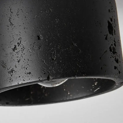 Rustic black travertine ceiling light with black matte cylindrical pendant and textured speckled surface for hallway decorbites black travertine