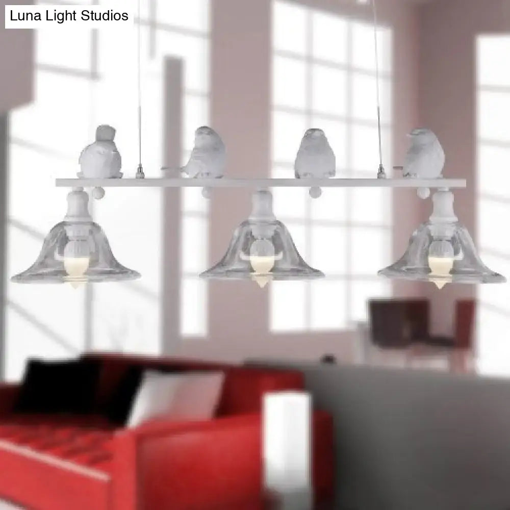 White ceramic bird figurines perched on decorbites™ rustic black island pendant lamp with clear glass shades