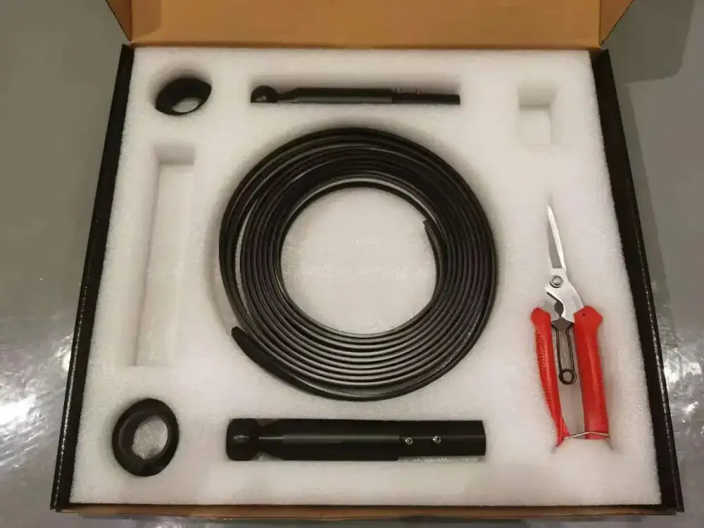 Black flexible inspection cable coiled in foam-lined box with tools for rustic black and white steel wall lamp strip decor
