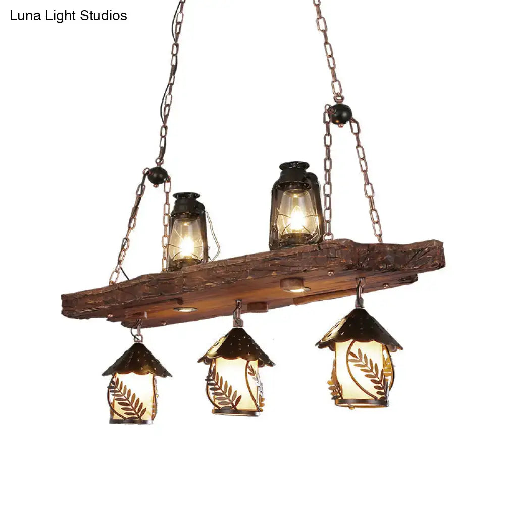 Rustic black wood lantern island ceiling light with wooden beam, three lanterns, and two amber glass leaf lamps