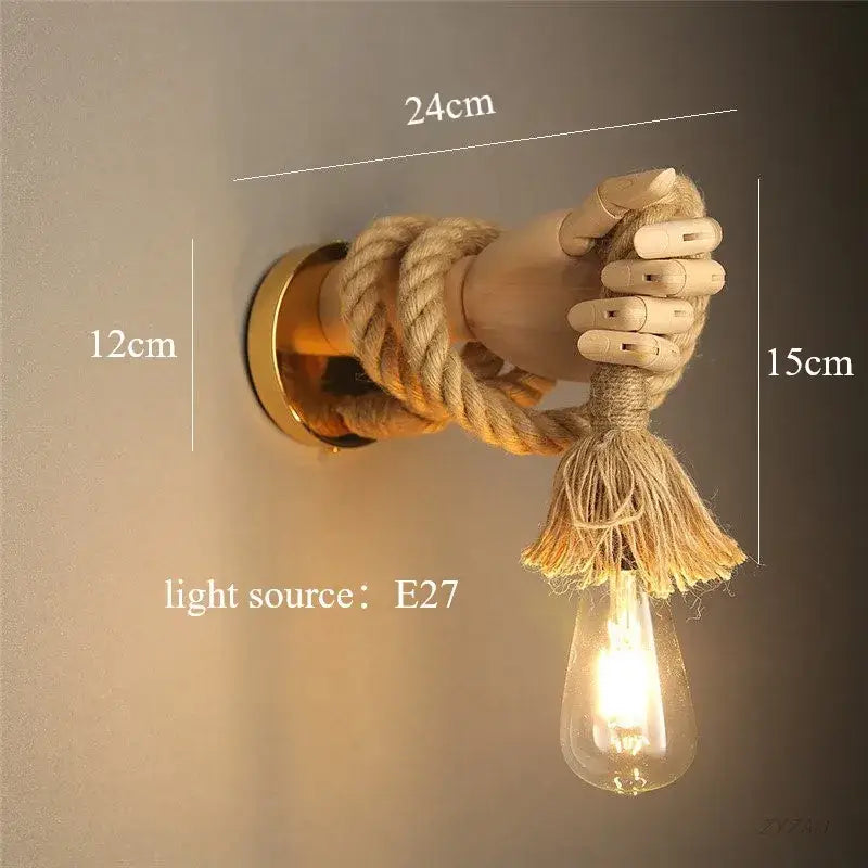 Rustic brass hand shape wall lamp with wooden hand and natural hemp rope supporting exposed filament bulb wall light