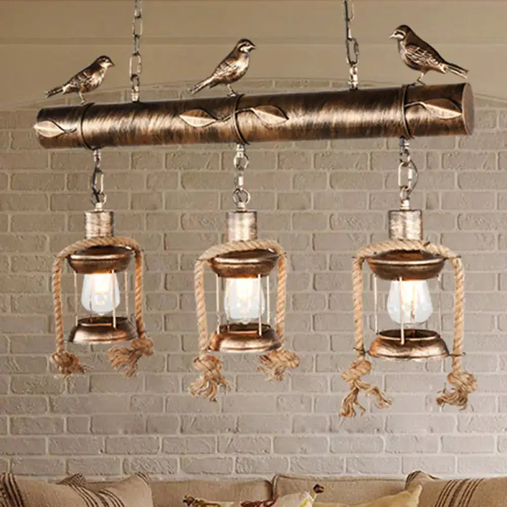 Bronze finished metal caged island pendant light with three lanterns and carved birds for kitchen or dining island lighting
