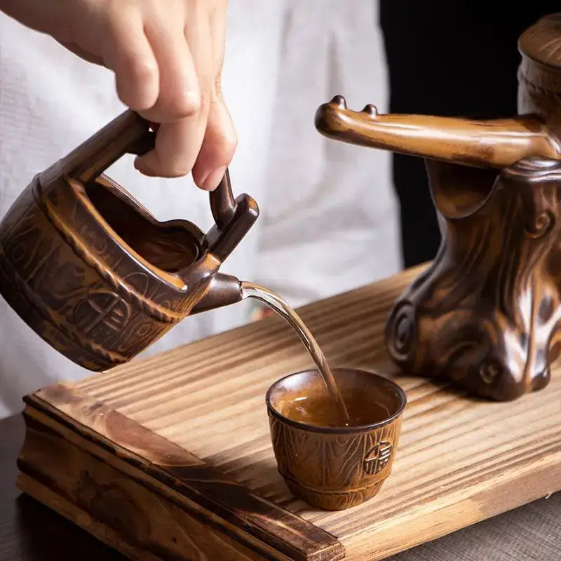 Rustic brown hand-carved ceramic tea set with intricate patterns pouring tea for tea brewing decorbites ceramic kung