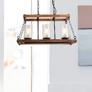 Rustic brown seed glass island light with wooden trapezoid guard and three clear candle bulbs on black metal chains