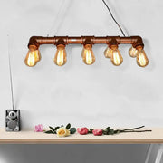 Copper pipe industrial pendant light with five exposed edison bulbs as metal linear island lighting for living room