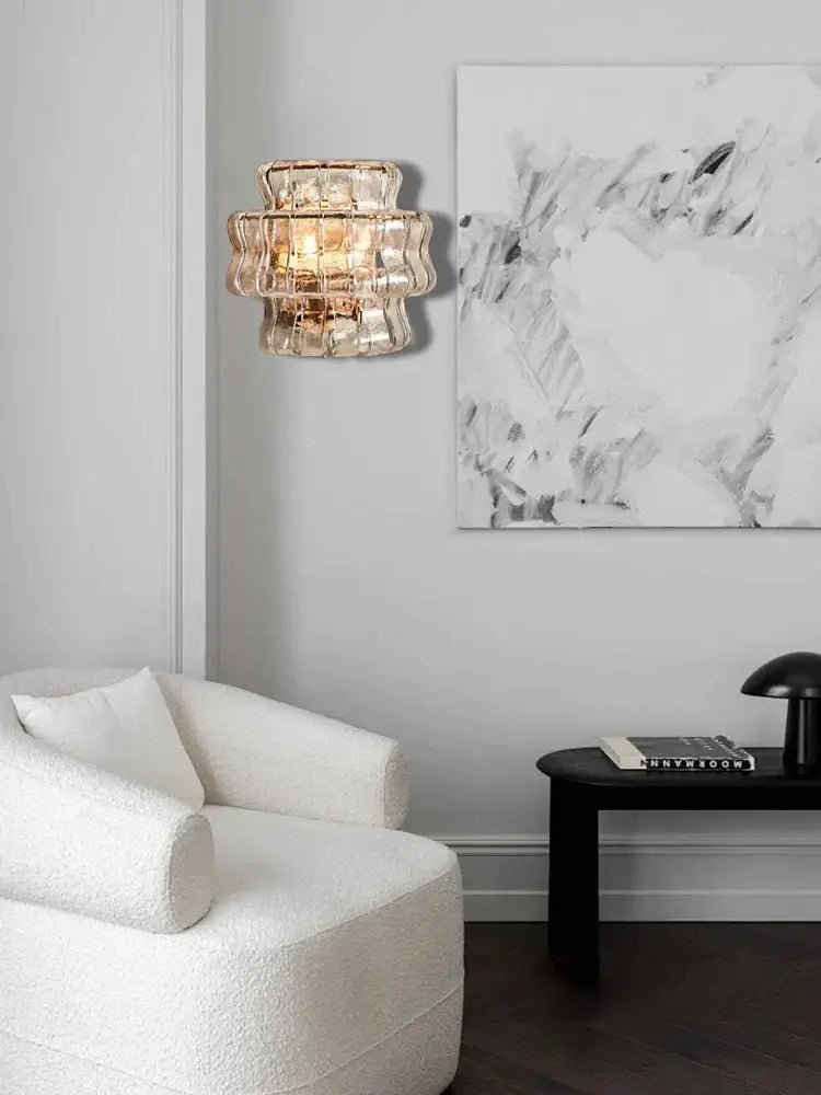 A rustic dark brown wall sconce lamp with tiered translucent gold-toned glass and faceted design for living room decor