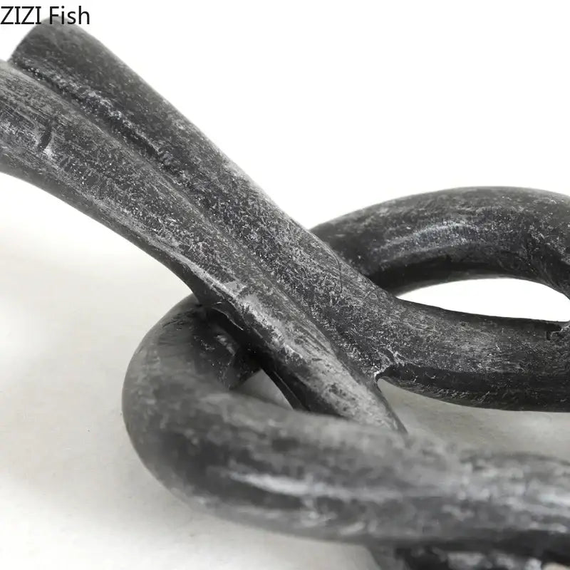 Rustic dark metal geometric knot resin sculpture featuring a textured hand-forged chain for living room decorbites geometric knot decor