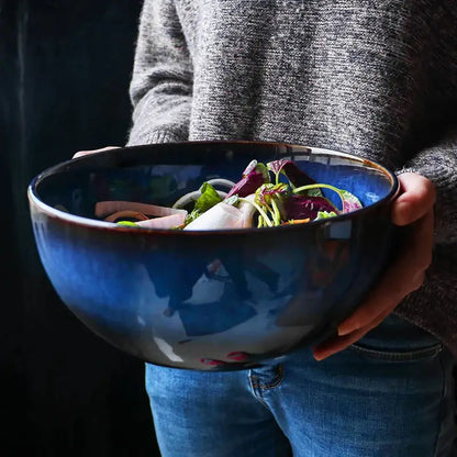 Rustic deep blue ceramic salad bowl with a glossy finish and wooden fork featuring ceramic porcelain design decorbites deep blue