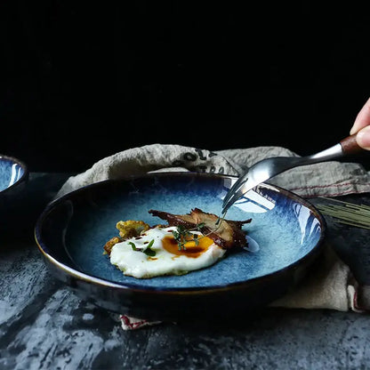 Rustic deep blue speckled decorbites ceramic salad bowl with glossy glaze holding sunny-side-up egg garnished with herbs