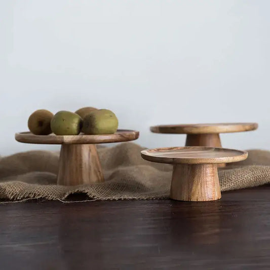 Three rustic decorbites elevated wooden cake stands with natural wood grain and warm light brown finish for serving