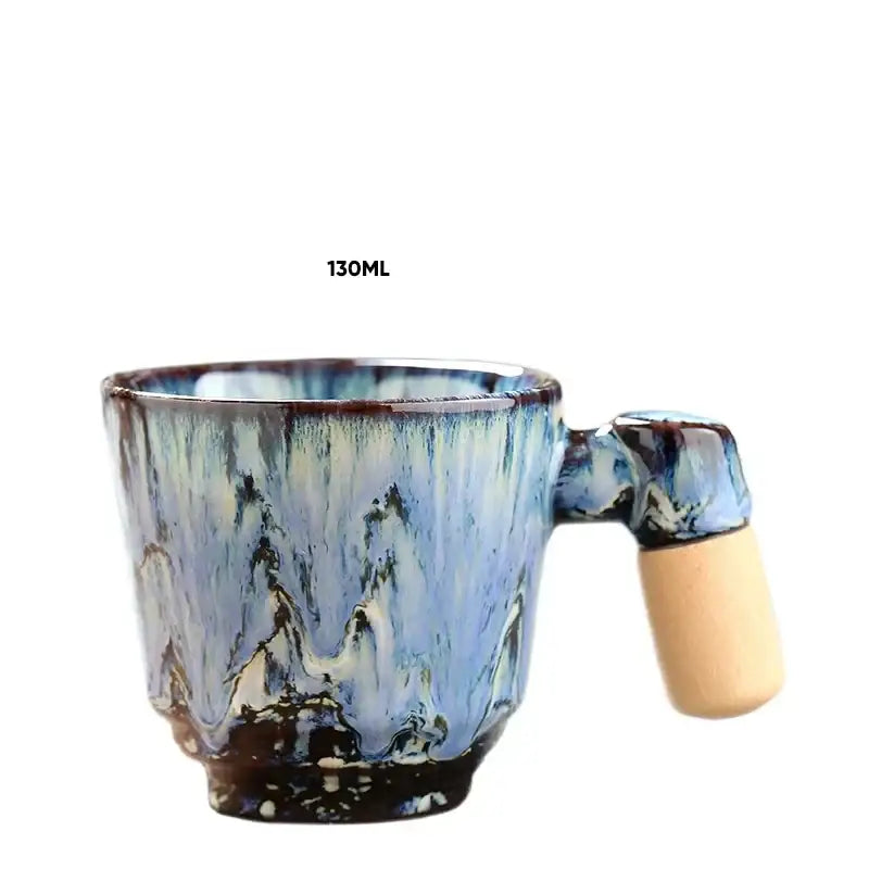 A 130ml ceramic latte mug with a swirling blue and brown glaze and a wooden handle for rustic kitchen drinkware
