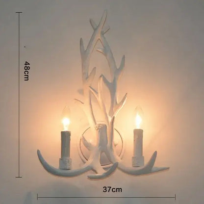 White antler-themed wall sconce with two candle-style bulbs complements rustic golden brown decorbites antler pendant chandelier