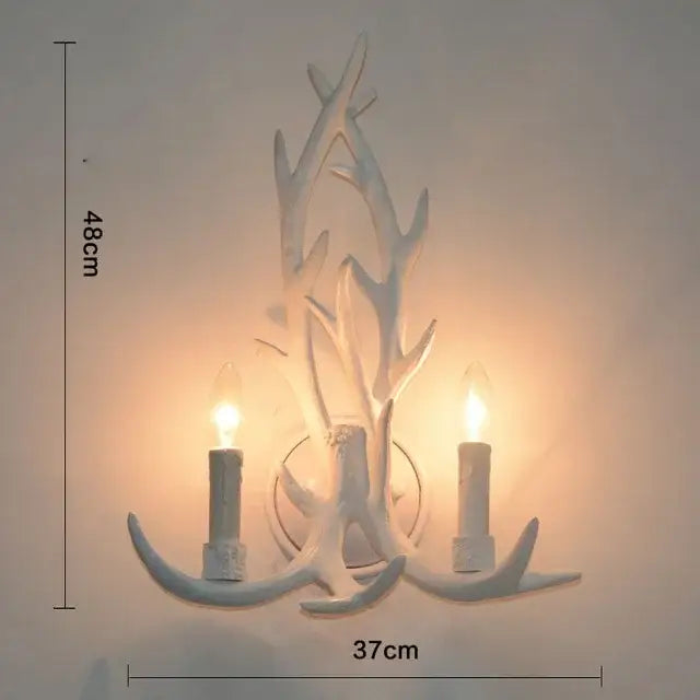 White antler-themed wall sconce with two candle-style bulbs complements rustic golden brown decorbites antler pendant chandelier