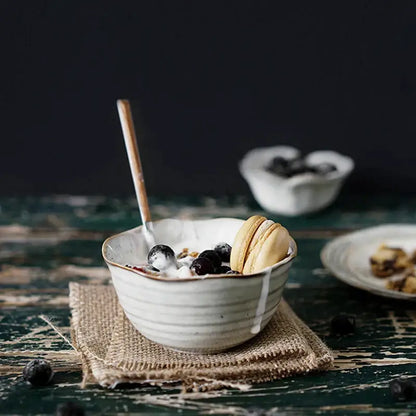 Rustic grayish white ceramic bowl set featuring a subtle ridged dish bowl filled with yogurt and blueberries
