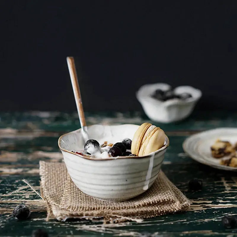 Rustic grayish white ceramic bowl set featuring a subtle ridged dish bowl filled with yogurt and blueberries
