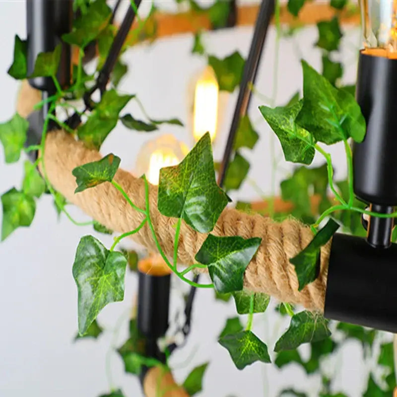 Rustic green leaf chandelier with rope wrapping, artificial green ivy vines, and exposed filament bulbs for dining room